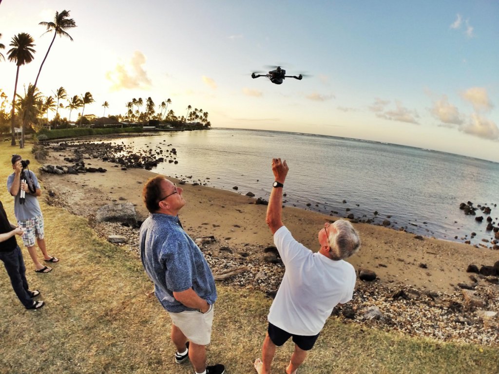 Researchers on a beach release a drone into the air