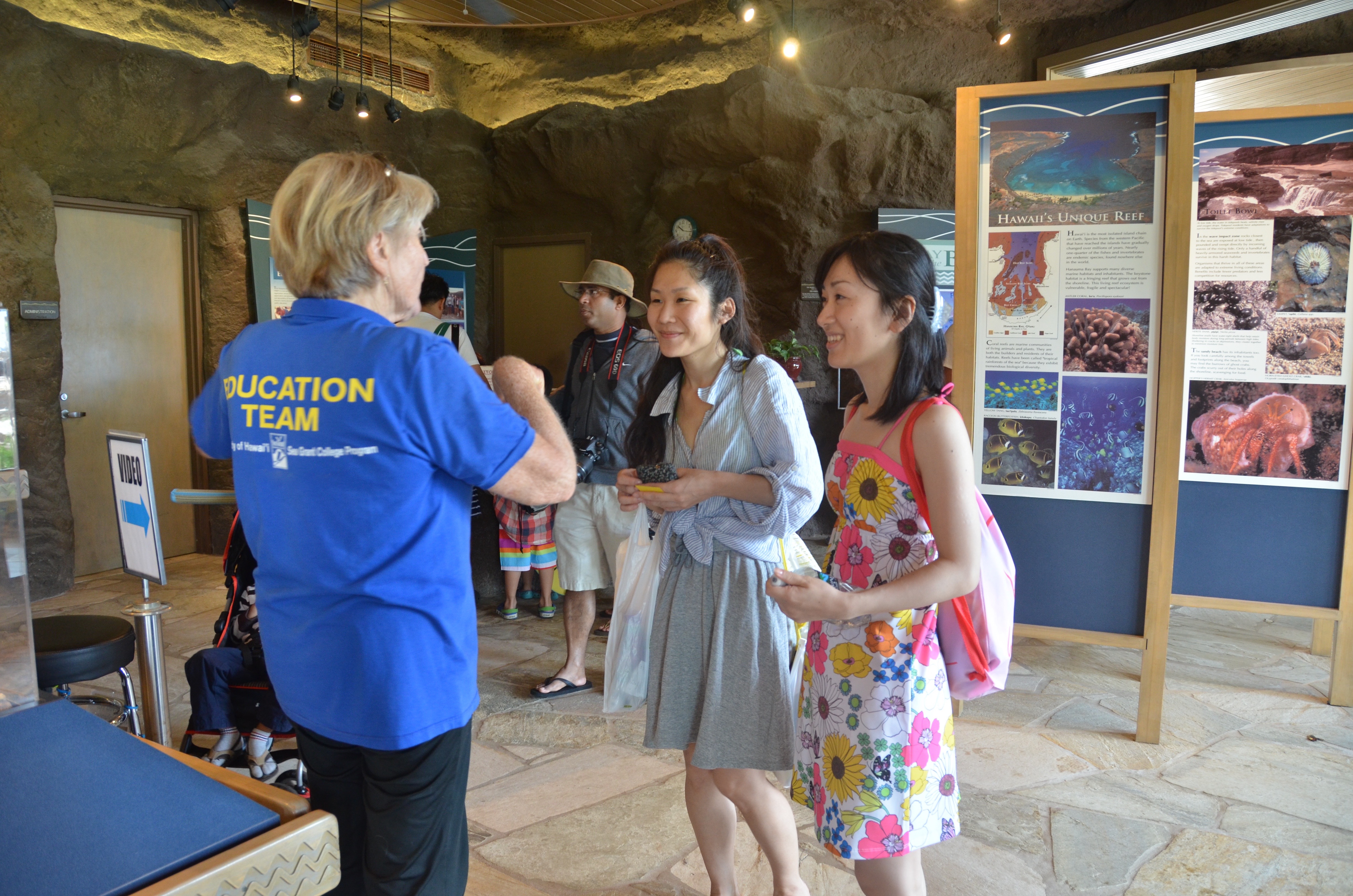 volunteer talking to two visitors at hanauma education center