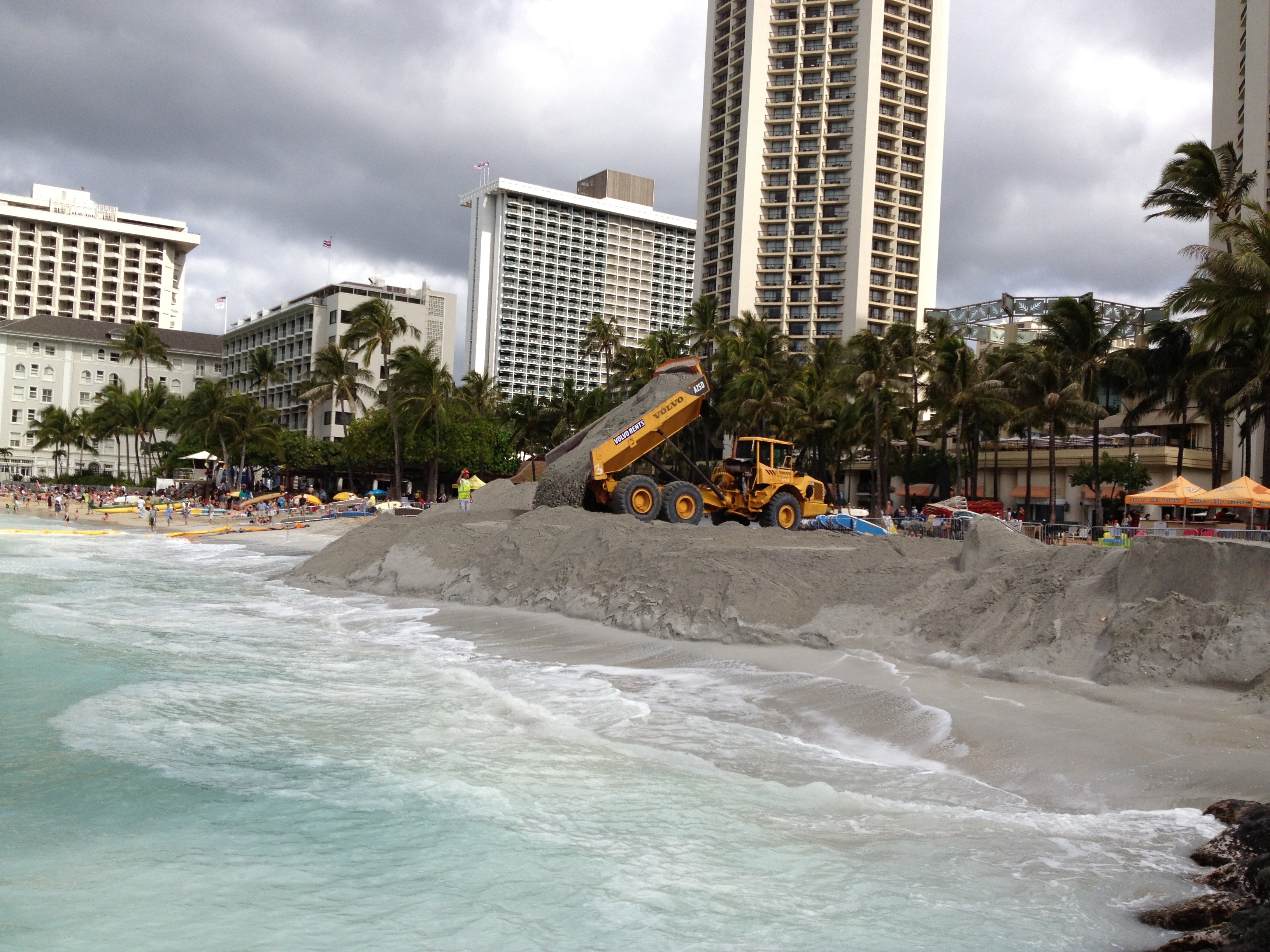 2012 Waikiki sand replenishment. A large truck is piling sand onto Waikiki Beach