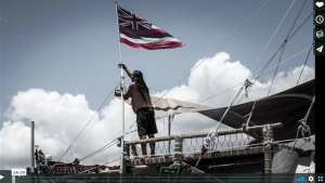 The Hawaiian Flag is raised on the Hokulea