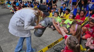 An educator shows a tank of dry ice to children at the SOEST Open House 2019