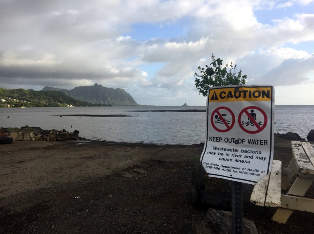 A water hazard sign sits near a beach