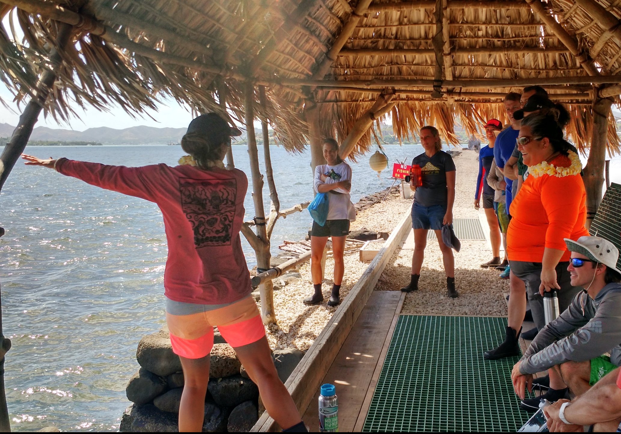 Fishpond workshop, nine people gather around a leader who is giving an explanation