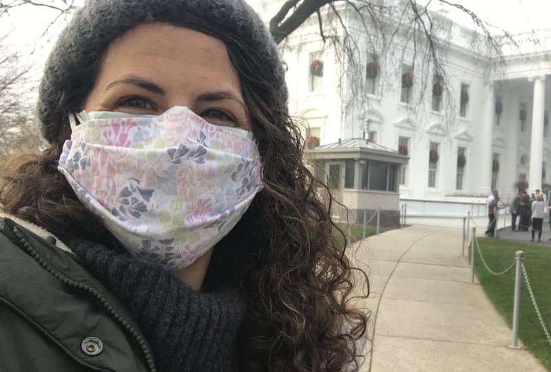 Beth Lenz (masked) poses for a selfie on a path to the White House