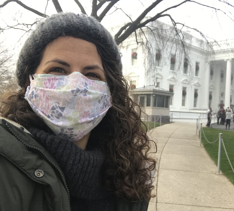 Beth Lenz (masked) poses for a selfie on a path to the White House
