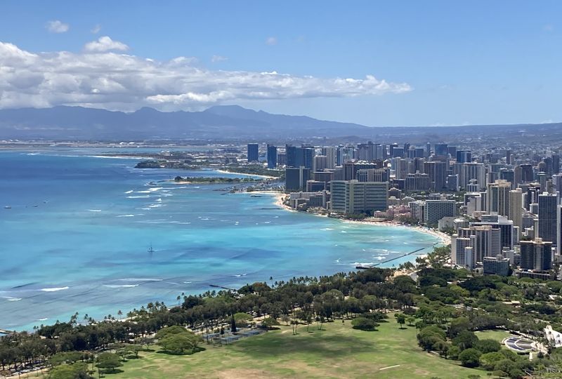 Scenic view looking down across the coastline and buildings of Waikiki, with the Waiʻanae Mountains in the background
