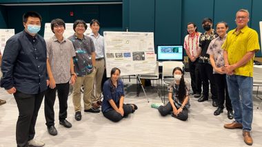 A group of engineers from the University of Hawaii at Manoa gather in front of their sustainability presentation board