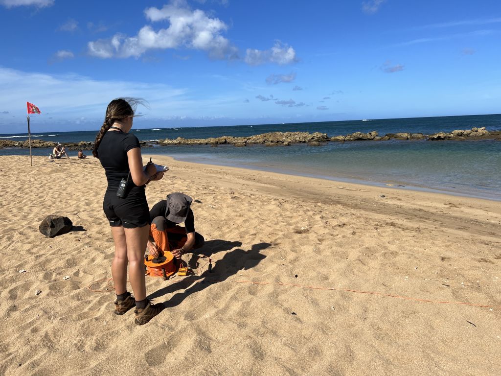 Two scientists stand on Salt Pond Beach to help complete the survey about Salt Pond